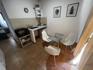 una piccola cucina con tavolo e sedie bianche di Hospedaje L H Ezeiza B a Ezeiza
