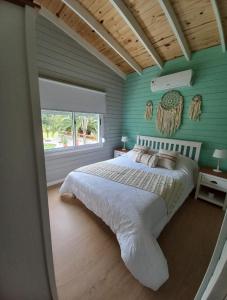 sypialnia z łóżkiem i zieloną ścianą w obiekcie Las Igoa w mieście Carmelo