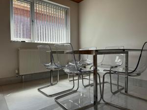 a glass table and chairs in an empty room at Instant Home in Luton