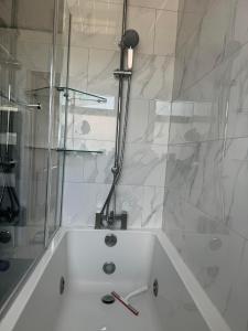 a bathroom with a shower and a white bath tub at Instant Home in Luton +53 photos