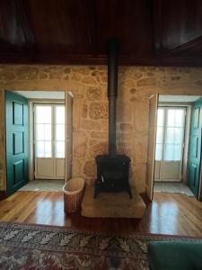 - un poêle à bois dans une chambre avec 2 fenêtres dans l'établissement Casa do Compasso, à Farminhão