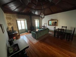 ein Wohnzimmer mit einer grünen Couch und einem Tisch in der Unterkunft Casa do Compasso in Farminhão