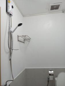een douche in een badkamer met een lampje aan de muur bij Hotel The Journey Patong New in Patong Beach