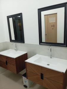 een badkamer met 2 wastafels en een spiegel bij Hotel The Journey Patong New in Patong Beach