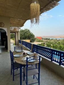 Makhfamane Land في Ouaouizelt: طاولة وكراسي على شرفة مطلة