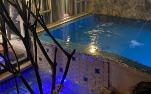 - une piscine avec des lumières bleues dans un bâtiment dans l'établissement Jung Ja Hut, à Sai Yok