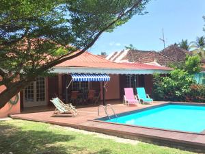 a house with a swimming pool in front of it at Les Villas Créoles de Sainte-Anne in Sainte-Anne