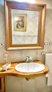 baño con lavabo y una foto en la pared en Casita excelente ubicación en San Carlos de Bariloche