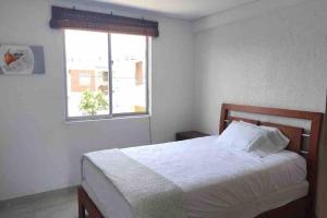 um quarto com uma cama e uma janela em Hermosa Casa en Restrepo, Meta em Restrepo