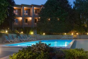 a swimming pool in front of a hotel at night at Hotel Villa Pax in Balatonalmádi