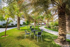 a table and chairs in a park with palm trees at Talah Resort in Riyadh