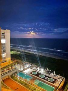 Blick auf ein Gebäude mit Pool in der Nacht in der Unterkunft Condomínio pé na areia com lazer completo - PCD in Barra Velha