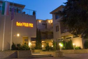 a building with a sign that reads inside wildlife park at night at Hotel Villa Pax in Balatonalmádi