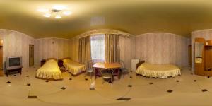 a living room with two beds and a tv at Alladin Hotel in Orenburg