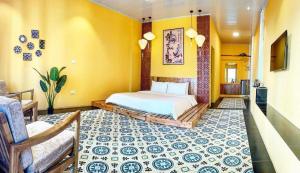 a bedroom with a bed and a yellow wall at Ầu ơ Homestay - Venuestay in Tam Ðảo
