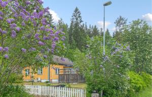 a house with purple flowers in front of a fence at Beautiful Home In Tranås With Ethernet Internet in Tranås +13 photos