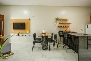 eine Küche mit Tisch und Stühlen und einer Theke in der Unterkunft Casa no PREÁ COM PISCINA ! in Prea