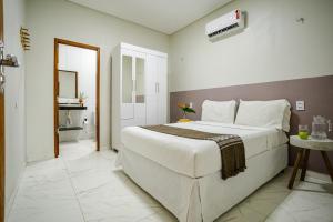 ein Schlafzimmer mit großem Bett und ein Badezimmer in der Unterkunft Casa no PREÁ COM PISCINA ! in Prea