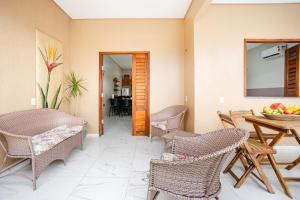ein Wohnzimmer mit Korbstühlen und einem Tisch in der Unterkunft Casa no PREÁ COM PISCINA ! in Prea