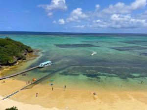 a view of a beach with a boat in the water at Hotel Monterey Okinawa Spa & Resort in Onna