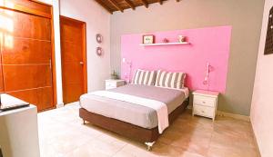 una camera rosa con letto e parete rosa di Malaika Hostel Medellín a Medellín