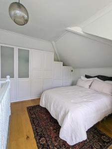 een witte slaapkamer met een groot bed en een tapijt bij Sun-Kissed Sanctuary by Battersea Park in Londen