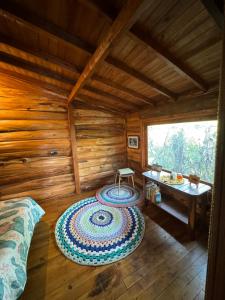 a room with a bed and a table in a log cabin at Beehouse Mandala in Guarne