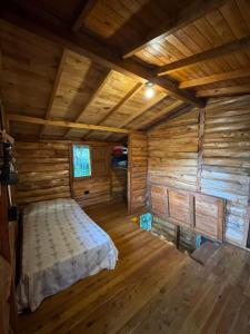 a bedroom of a log cabin with a bed at Beehouse Mandala in Guarne