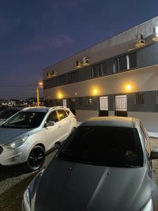two cars parked in a parking lot in front of a building at Loft BR 282 próximo ao shopping com Ar-condicionado in Lages
