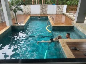 a man and a woman swimming in a swimming pool at Hotel Sítio Novo in Piratuba