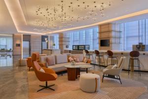 a lobby with a couch and chairs and a table at Hyatt Place Nantong Xinghu City Plaza in Nantong