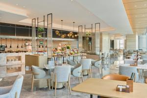a restaurant with tables and chairs and a bar at Hyatt Place Nantong Xinghu City Plaza in Nantong