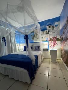a bedroom with a blue bed with a canopy at Flats Bela Vista Grécia in Macaé