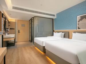 Postel nebo postele na pokoji v ubytování Country Inn & Suite by Radisson, Guangzhou Railway Station Xiaobei