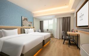 Postel nebo postele na pokoji v ubytování Country Inn & Suite by Radisson, Guangzhou Railway Station Xiaobei