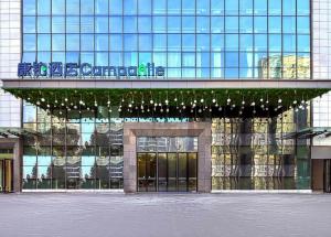 a large glass building with a sign on it at Campanile Changsha Songya Lake in Changsha