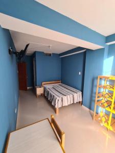 1 dormitorio con cama y pared azul en LIRI House en Oxapampa