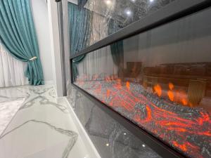 アティラウにあるШикарная ЖК New Cityの暖炉付きのリビングルーム