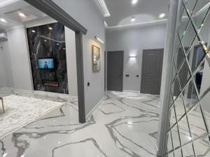 アティラウにあるШикарная ЖК New Cityの大理石の床と2つのドアがある廊下
