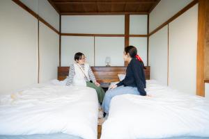 Postel nebo postele na pokoji v ubytování ゲストハウスくしロコ