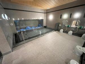 a bathroom with a bath tub with two toilets at Hotel Route-Inn Sapporo Ekimae Kitaguchi in Sapporo