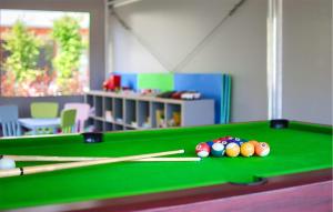 a pool table in a room with cue balls and chopsticks at 2 Bedroom Beautiful Home In Mrzezyno in Mrzeżyno +17 photos
