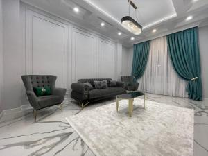 アティラウにあるШикарная ЖК New Cityのソファと椅子2脚のあるリビングルーム +3枚の写真