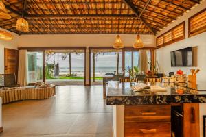 una cucina e un soggiorno con vista sull'oceano di Casa ADOBE Preá - FRENTE MAR! a Prea