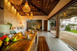 an open living room with a large wooden table at Casa ADOBE Preá - FRENTE MAR! in Prea