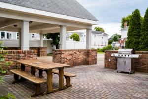 a picnic table and a grill on a brick patio at Spacious Home In A Quiet Neighborhood in Atlantic City