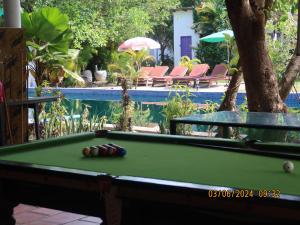 Bohemiaz Resort and Spa Kampot في كامبوت: طاولة بلياردو أمام المسبح
