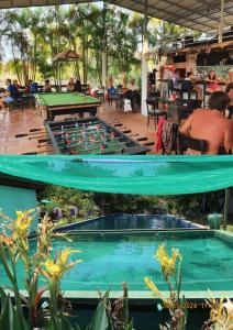 Bohemiaz Resort and Spa Kampot في كامبوت: حمام سباحة مع طاولة مع كرات البلياردو عليه