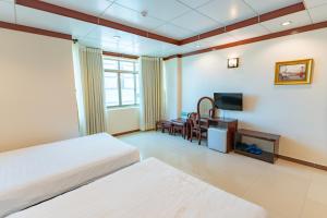una camera d'albergo con due letti e una televisione di Phúc Đạt Hotel a Vung Tau