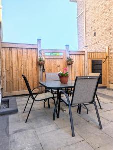 un patio con mesa, sillas y una valla en Urban Haven: 2BR/2BA+Office, Kitchen, Dining, en Newcastle